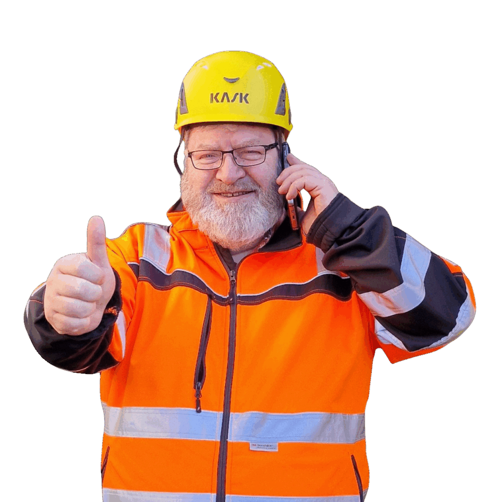 Doug Hallam in Schutzkleidung und Helm zeigt Daumen hoch – Ihr Ansprechpartner für Drohnenvermessung, Thermografie und Luftbilddokumentation.