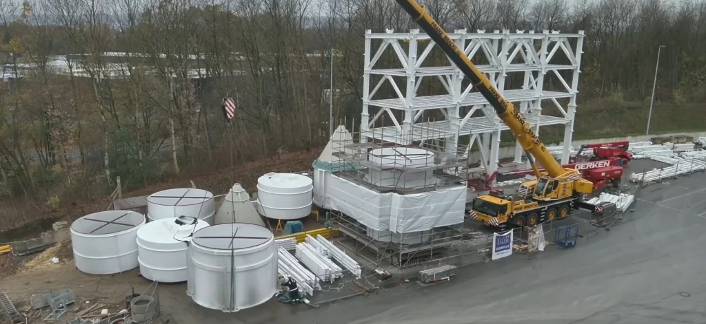 Drohnenaufnahme eines Kraneinsatzes beim Positionieren eines Silos auf einer Industriebaustelle – TechPic Baustellendokumentation mit Baufortschrittsverfolgung