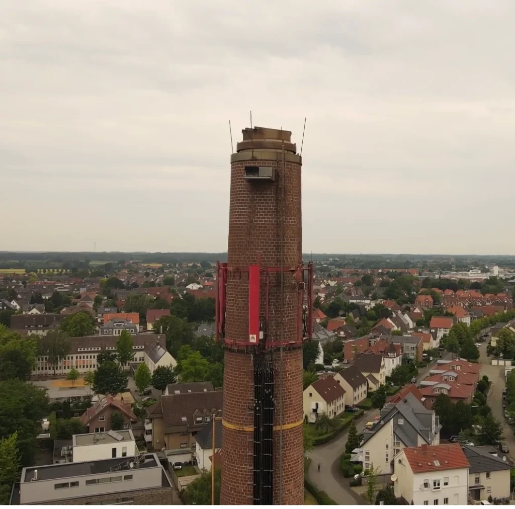 Drohnenaufnahme eines Industrie-Schornsteins mit Blitzschutzanlagen und Adlernest – schwer zugängliche Anlage in einer Fabrik in Rhed